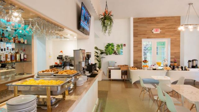 A buffet-style breakfast setup with food, drinks, and tables.