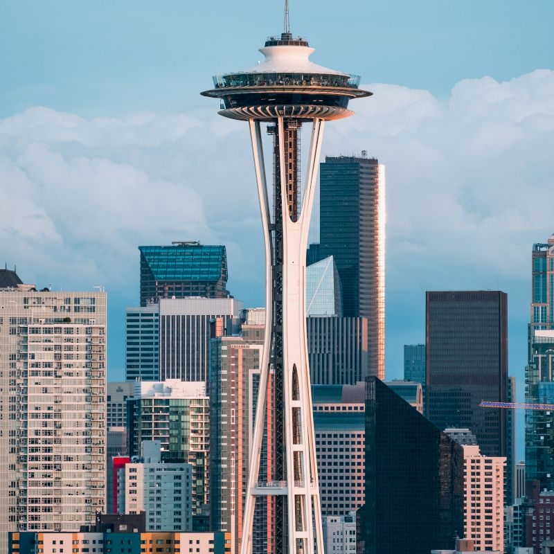 The image shows the Space Needle, an iconic observation tower in Seattle, with the city skyline in the background.